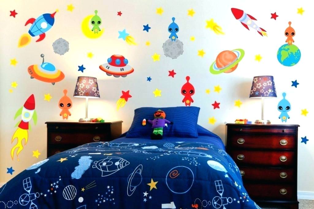 اتاق کودک پسر با تم فضا نوردی که دیوار و تخت آن با استیکر و روتختی با طرح منظومه شمسی و آدم فضایی دیزاین شده است